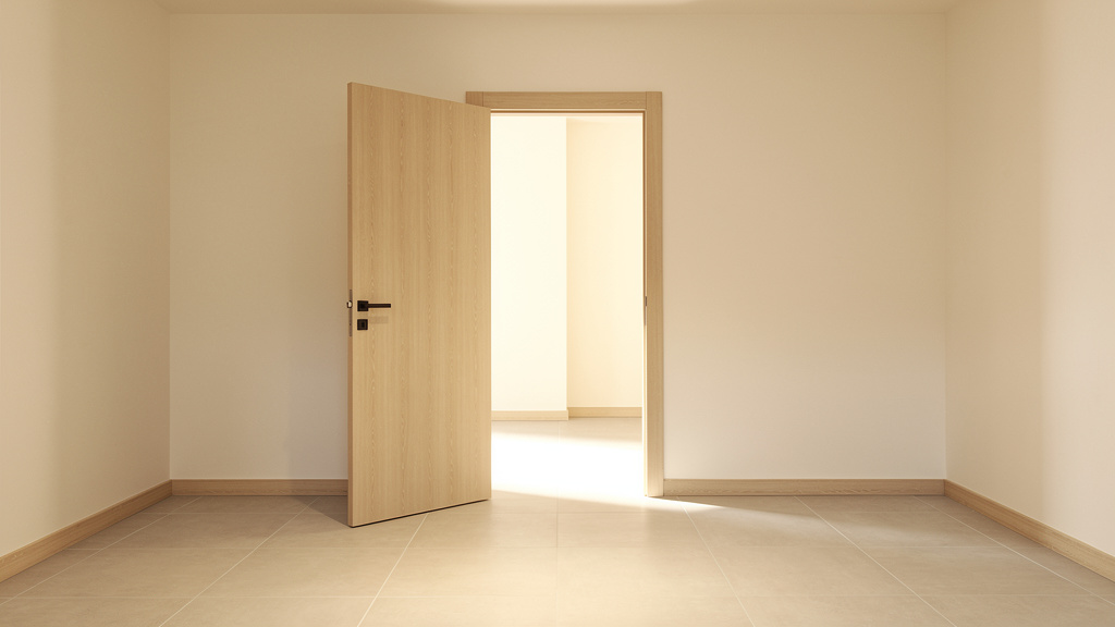 An open door into a bright, empty room.